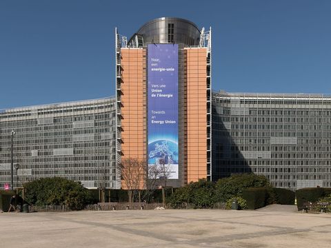 Berlaymont-Gebäude der EU-Kommission in Brüssel mit großem Banner unter blauem Himmel