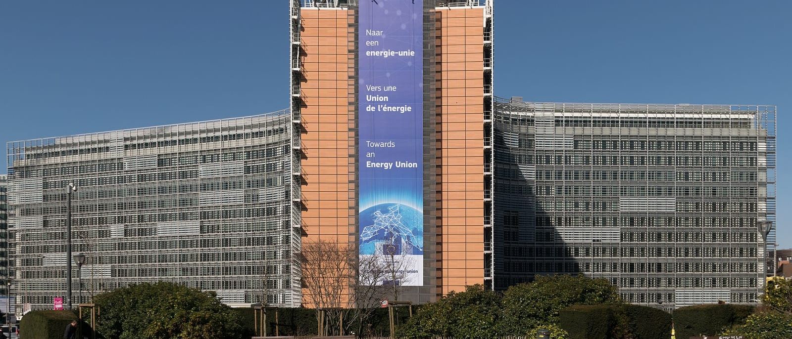 Berlaymont-Gebäude der EU-Kommission in Brüssel mit großem Banner unter blauem Himmel