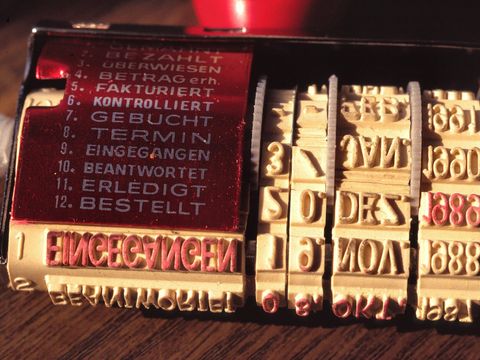 Alter Buchungsstempel mit Datumsrädern und Feldern wie Fakturiert, Gebucht und Bezahlt