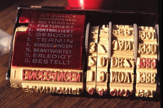 Alter Buchungsstempel mit Datumsrädern und Feldern wie Fakturiert, Gebucht und Bezahlt